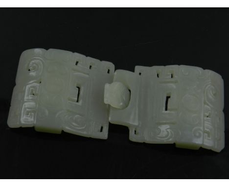 A Chinese celadon jade belt buckle, having pierced decoration and carved with C-scrolls and Lu symbols. L. 12cm