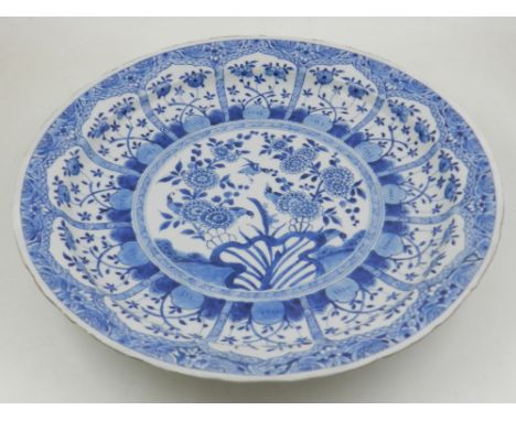 A late 17th / early 18th century Chinese Kangxi period blue and white charger, decorated with a central circular panel of swa