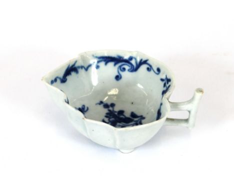 An 18th Century Worcester butter boat, with moulded flowerhead feet and angular handle, blue and white floral spray decoratio