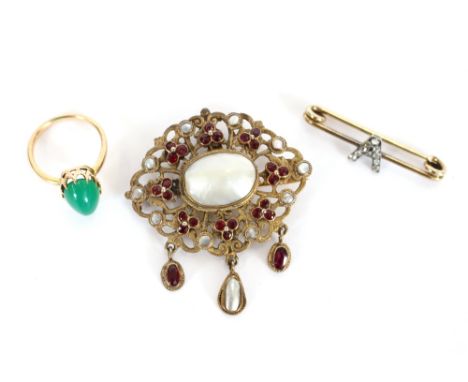 A yellow metal seed pearl, mother of pearl and garnet set brooch; a bar brooch decorated with a paste set "A"; and a yellow m