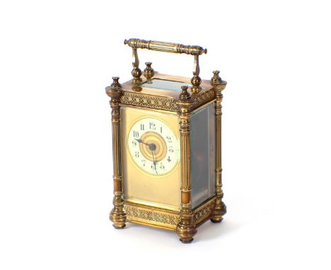 A brass cased carriage timepiece, decorated reeded columns and foliate frieze beneath a swing handle, circular enamel dial, 1