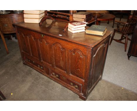 An Antique oak mule chest, the hinged top above five fielded arched panels and two drawers below, raised on bracket supports,