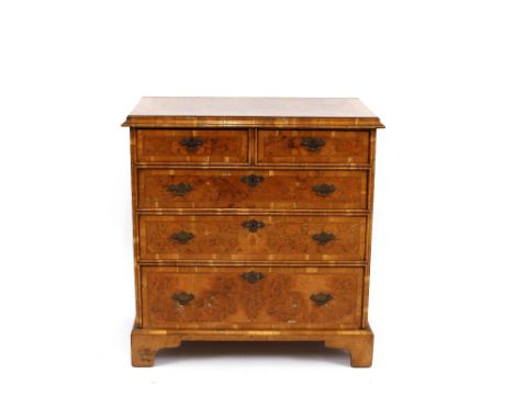 A burr walnut veneered chest, of early 18th Century design, cross-banded and herring bone inlaid top above two short and thre