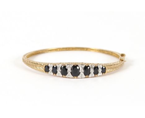 A 9 carat gold sapphire and diamond bangle, total weight 14.4gms