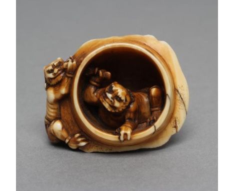 A JAPANESE IVORY NETSUKE, Meiji period, of two Oni cleaning the Cauldron of Hell, signed Naokazu, 1 1/2" wide (Est. plus 21% 