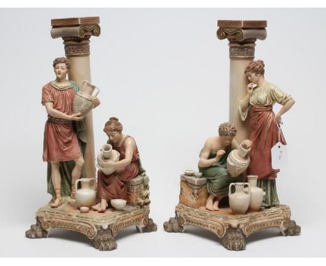 A PAIR OF ROYAL DUX FIGURAL LAMP BASES, early 20th century, both with a standing figure beside a classical column and a seate