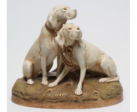 A ROYAL DUX MODEL OF TWO HOUNDS, early 20th century, seated on an oval base, model 1583, pink patch, 11 1/2" high (Est. plus 