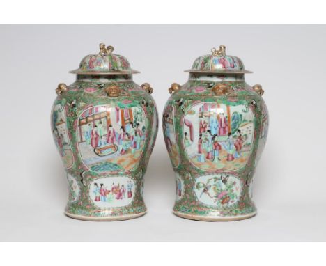 A PAIR OF CHINESE PORCELAIN JARS AND COVERS of inverted baluster form each with four pierced mask lugs to the shoulders, pain