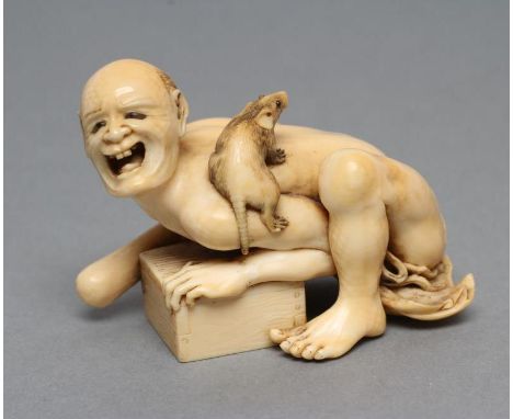 A JAPANESE IVORY SMALL OKIMONO NETSUKE, Meiji period, of a disappointed rat-catcher, half kneeling and pressing down on a tra