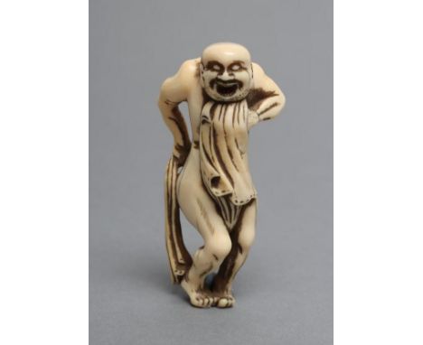 A JAPANESE IVORY NETSUKE, Meiji period, the old man in the process of tying his fundoshi, unsigned, 2 1/2" high (Est. plus 21