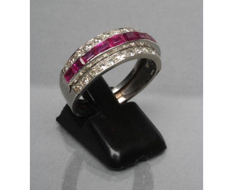 A RUBY AND DIAMOND HALF HOOP RING, the ten graduated calibre cut rubies channel set to a border of pave set small brilliant c