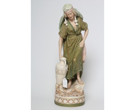 A ROYAL DUX FIGURE, early 20th century, the young Eastern female holding an amphora in her right hand standing barefoot on a 