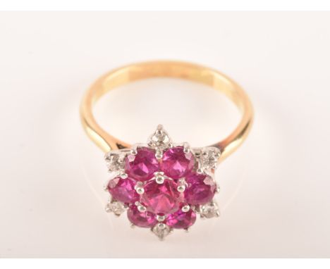 A yellow and white metal synthetic ruby and diamond cluster ring, set to centre with a round ruby with an approximate weight 