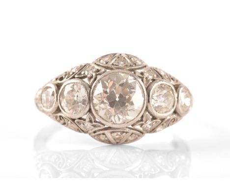 An early to mid 20th century platinum and diamond ring, collet-set with five graduated diamonds, pierced openwork surround mo