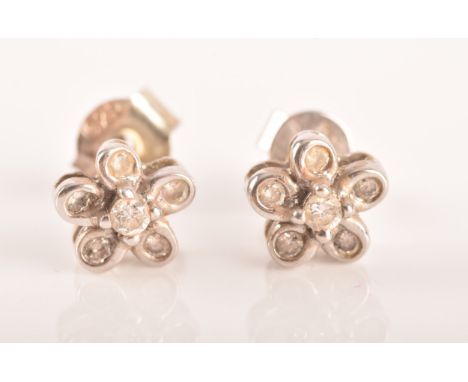 A pair of 18ct white gold diamond set floral earrings, each set to centre with a brilliant cut diamond with an approximate we