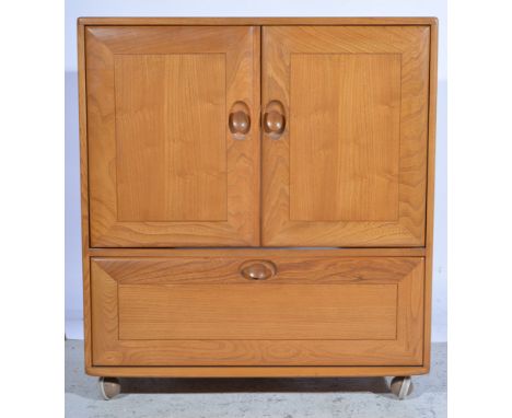 Ercol, a television cabinet, elm, pair of cupboards above a fall front drawer with retractable multimedia shelf, raised on ca