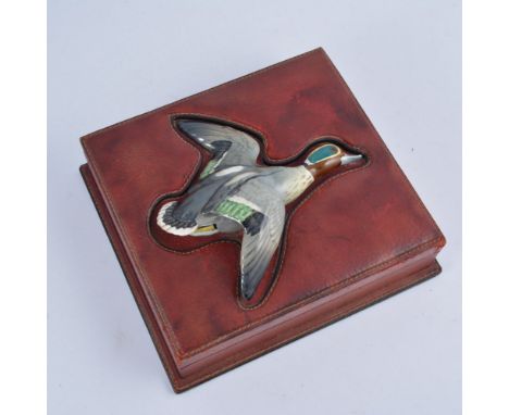 Stitched maroon leather cigar box, the cover inset with a pottery model of a flying duck, the underside stamped stamped Made 