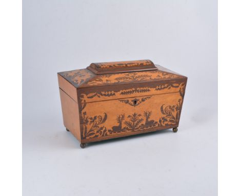 A birds eye maple and rosewood tea caddy, casket form, with scrolling designs to each panel, the front panel with resting sta