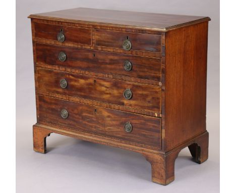 A George IV inlaid mahogany chest fitted two short &amp; three long graduated drawers with later brass ring handles, on tall 