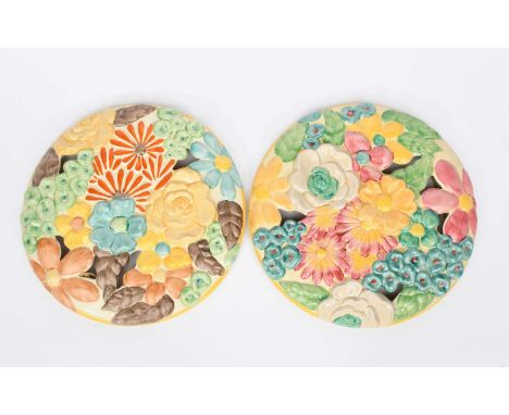 A matched pair of Clarice Cliff My Garden floral wall plaques, circular, cast in low relief with flowers, painted in colours 
