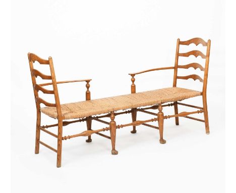 An ash ladder backed three seat settle designed by Sir Edwin Lutyens, for Deanery Garden, Sonning, with rush seating,unsigned