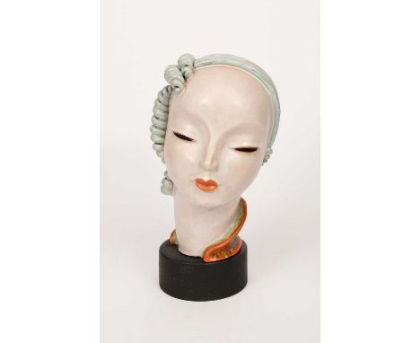 A large Goldscheider Pottery bust, modelled with stylised featured, glazed in orange and pale blue, on ebonised wood base, ap