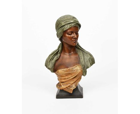 An Art Nouveau Goldscheider Pottery bust of a Woman, designed by Simon, model no.1340, modelled with down cast gaze, wearing 