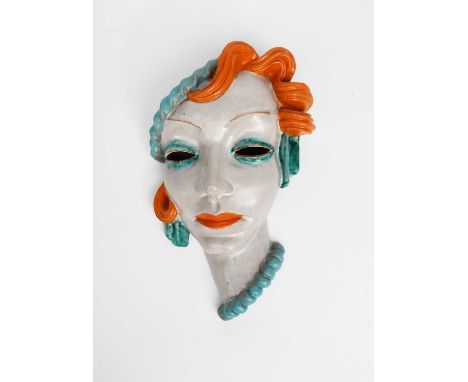A Goldscheider Pottery wall mask, model no.6335, modelled as a woman with stylised features wearing a blue beret, in blue and