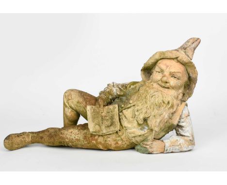 An Austrian pottery model of a Gnome, model no.6359, modelled lying on his side holding a book, glazed in colours impressed f