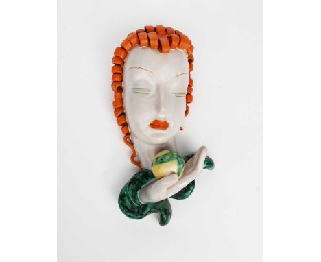 A Goldscheider Pottery wall mask, model no.6774, modelled as a woman with stylised features holding an apple to her face, gla