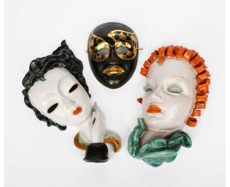 A Goldscheider Pottery wall mask, model no.6775, modelled as a woman with orange ringlets, glazed in colours, another Goldsch