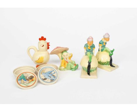 A pair of Clarice Cliff Novelty Pixie book ends, each modelled as a pixie with shell hat, seated on a mushroom. glazed in col