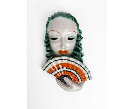 A Goldscheider Pottery wall mask, model no.6542, model as a woman with stylised features, holding a fan to her face, glazed i