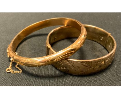 A gold coloured metal hinge bangle, compression clasp, safety chain &amp; buckle, indistinctly marked, 20.3g;  another rolled