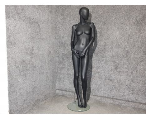A large female shop mannequin on glass stand