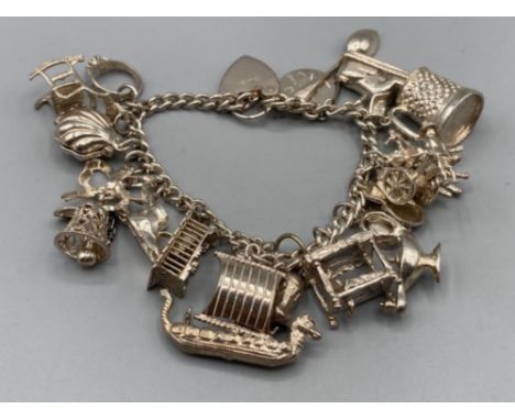Silver charm bracelet with 18 assorted charms 65g