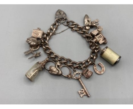 A silver charm bracelet with silver and white metal charms 62.5g gross