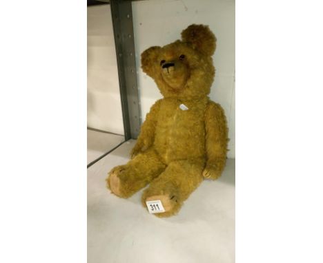 An early 20th century straw filled teddy bear