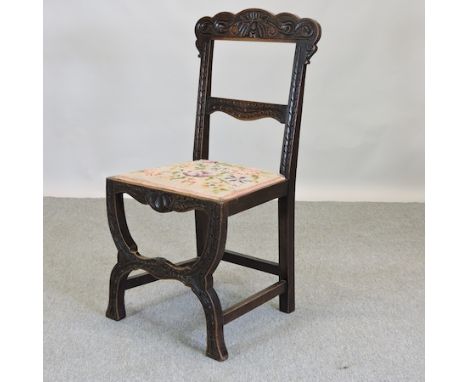 A 19th century heavily carved dark oak side chair, with a padded tapestry seat