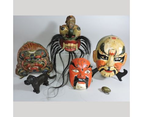 A cast iron nutcracker in the form of a dog with patent number, 10cm tall, together with a collection of eastern war masks 