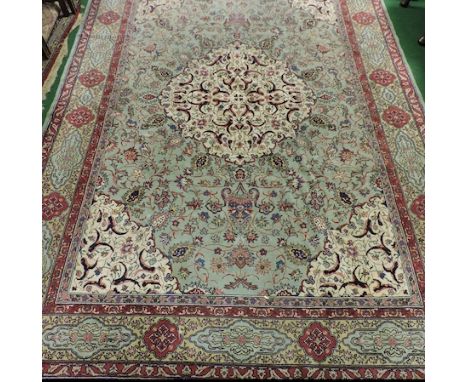 A Persian woollen carpet, with a central medallion, on an ivory field, within multiple borders, 340 x 235cm