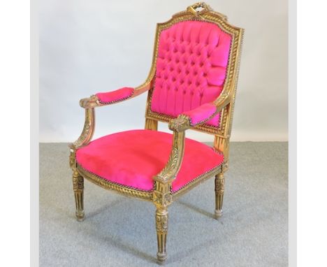 A reproduction gilt painted and pink upholstered button back open arm chair