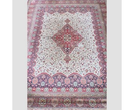 A Persian woollen carpet, with floral designs on a red ground, 393x298cm