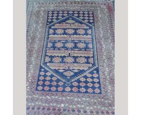 A Turkoman style carpet, with nine rows of medallions, on a blue ground, 290 x 390cm