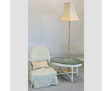 A cream painted occasional table, 83cm, together with a nursing chair, with a green loose cover, and a brass standard lamp