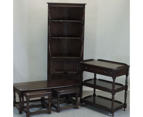 An Ercol dark elm standing corner cupboard, 76cm, together with a three tier trolley and a nest of tables