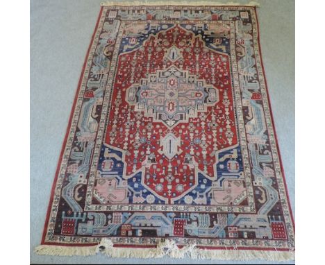 A Persian woollen carpet, with a central medallion and geometric designs, on a red ground, 243 x 170cm