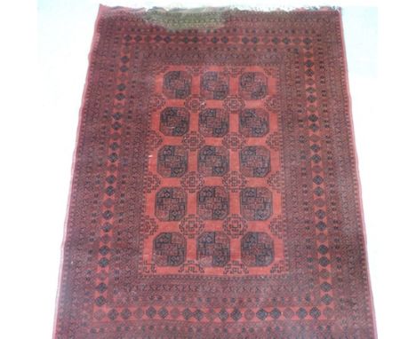 An Afghan carpet, with rows of central medallions on a red ground, 278 x 211cm 
