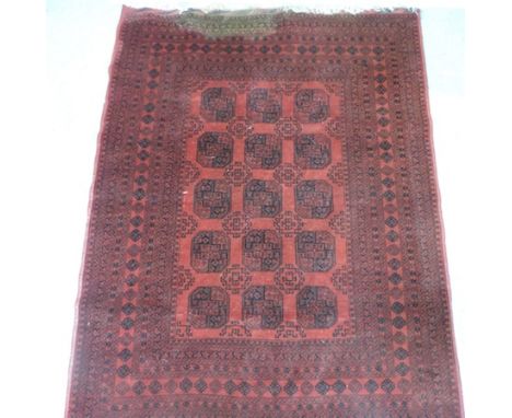 An Afghan carpet, with rows of central medallions on a red ground, 278 x 211cm 