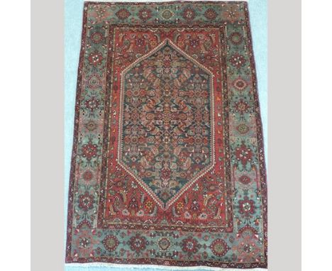 A Persian carpet with floral designs on a red ground, 210 x 136cm